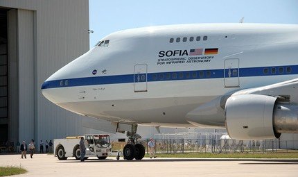 SOFIA Boeing 747SP being towed out of its hangar by a tug, seen from the front