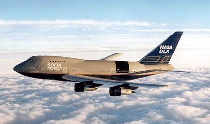 SOFIA Boeing 747SP in flight above cloud in an early gold and white scheme with NASA and DLR tail markings