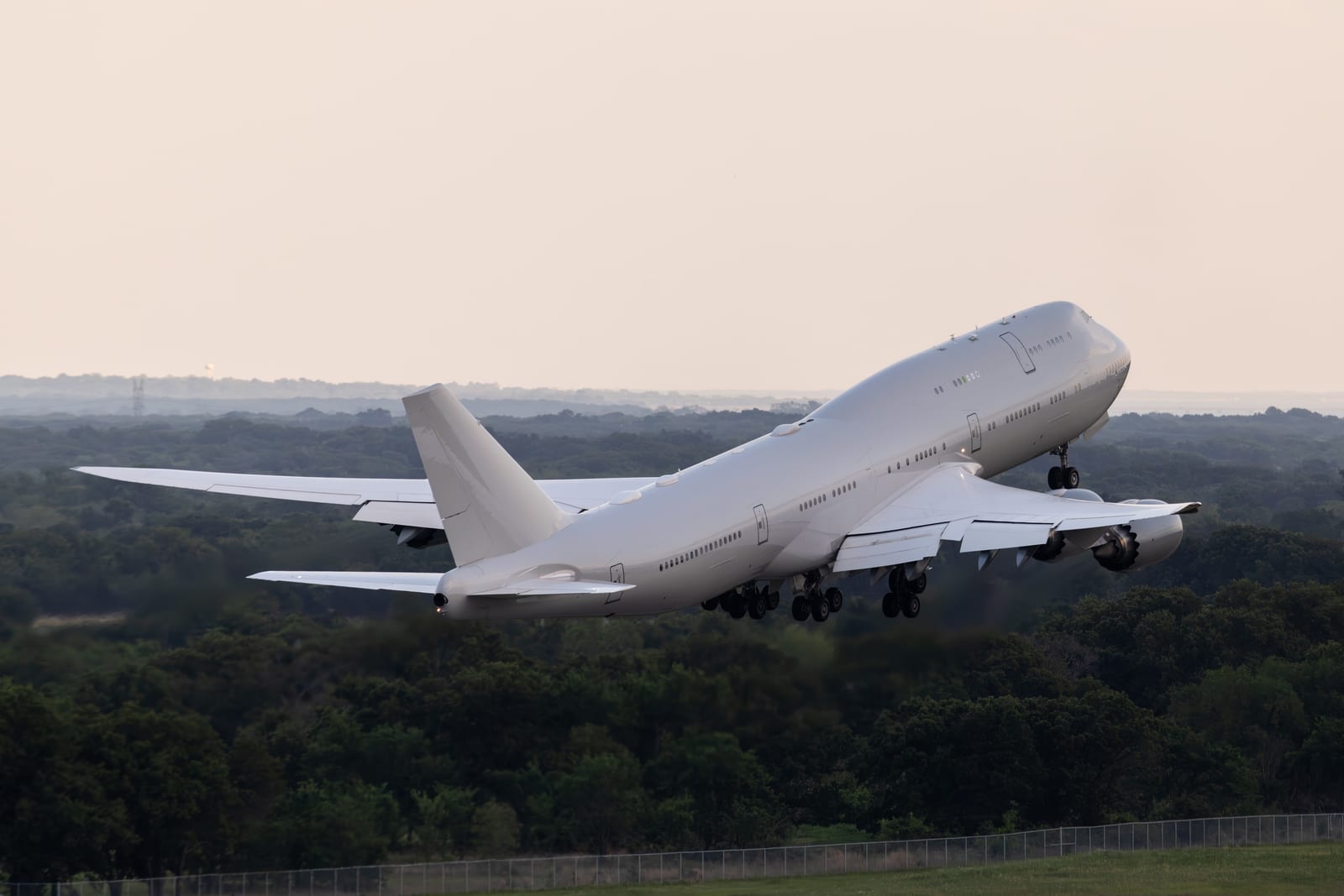 Boeing 747-8 in bare white paint lifting off with its landing gear still extended during flight testing at Greenville, Texas